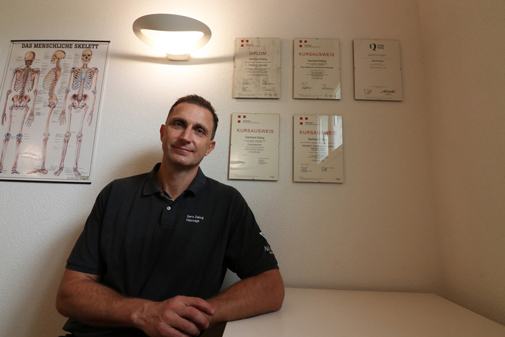 Foto von Gero vor seinen Diplomen in der Massagepraxis im Thurgi-Center in Amriswil
